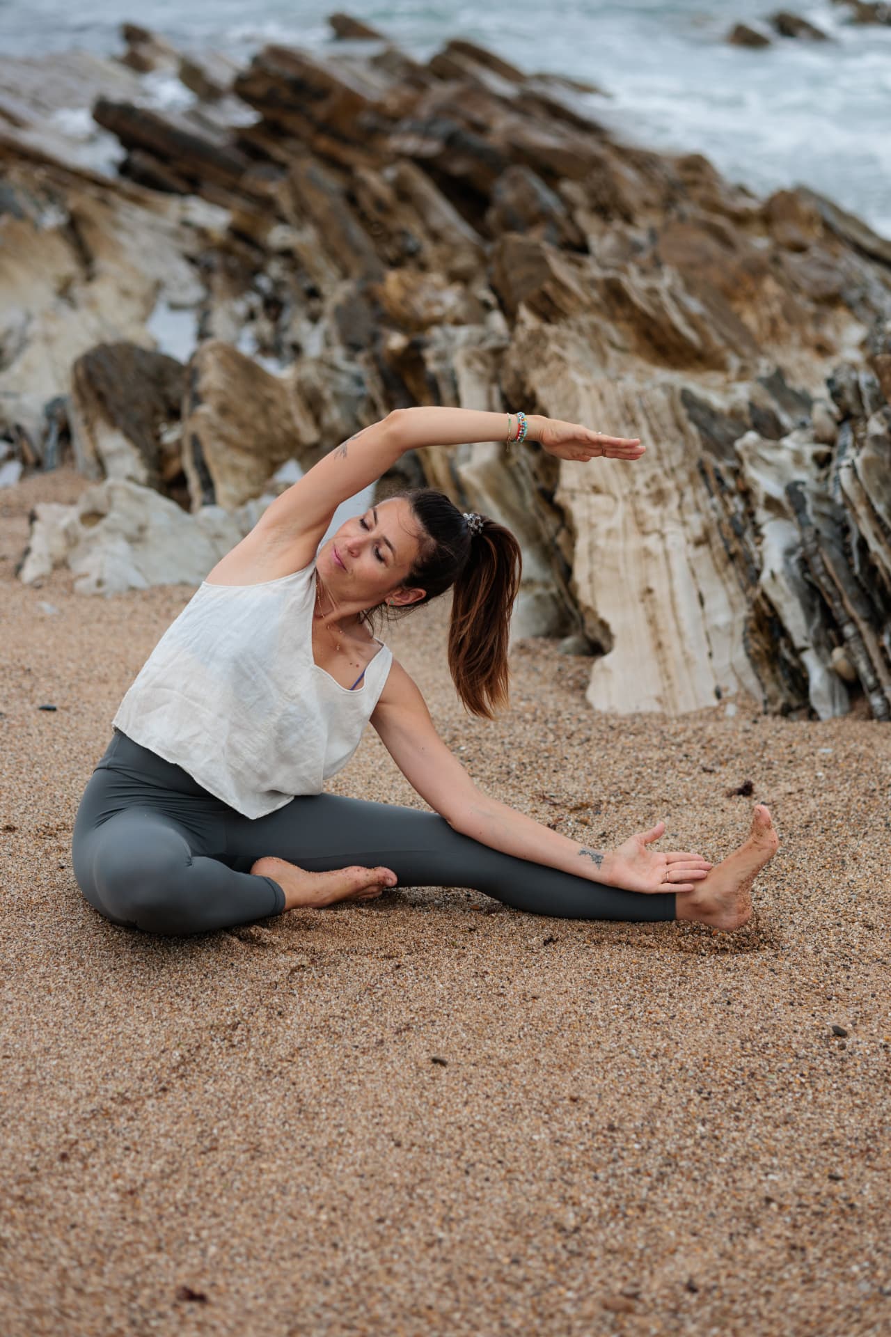 Fanny Gand, professeure de yoga prénatal, en étirement sur la plage