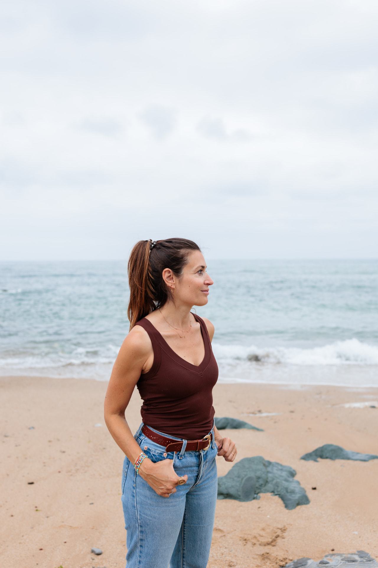 Fanny Gand, sophrologue, debout face à l'océan sur la plage